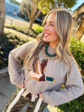 This soft mocha knit features a mallard duck design in warm neutral shades of brown, gray, and rust.