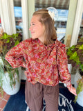 This long sleeve top features a ruffled neckline with a self-tie detail for a polished, elevated touch. 