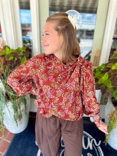  This long sleeve top features a ruffled neckline with a self-tie detail for a polished, elevated touch. 