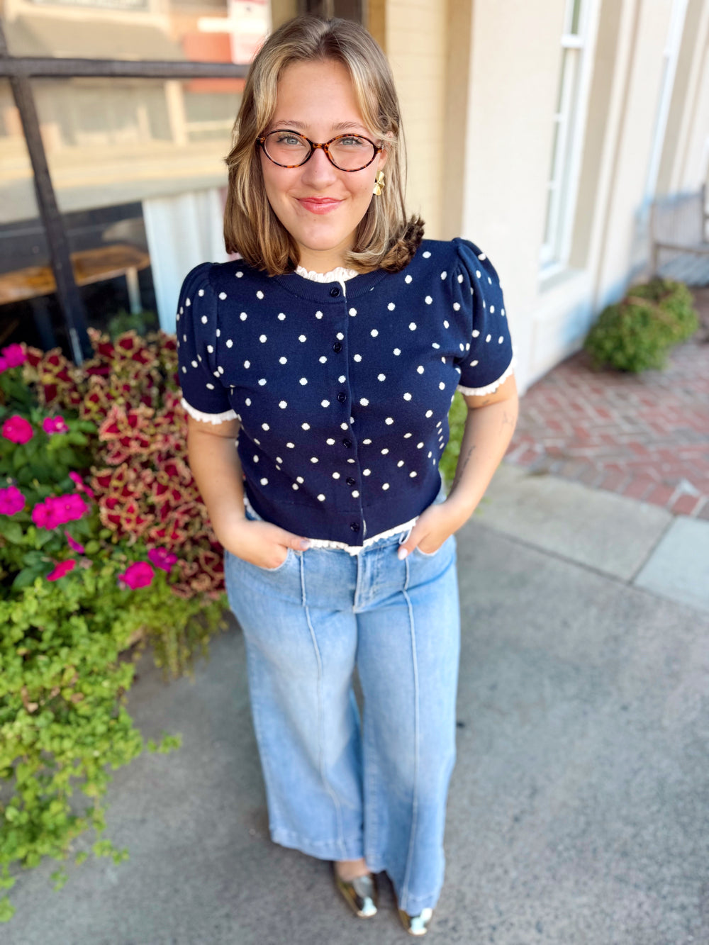  This polka dot sweater top features a button-down front with delicate lettuce-edge hems for a sweet, feminine finish. 
