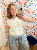 This cardigan features a classic cream color with a button-front design and feminine short sleeves.