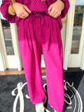 Magenta striped wide-leg pants with an elastic waist and drawstring.