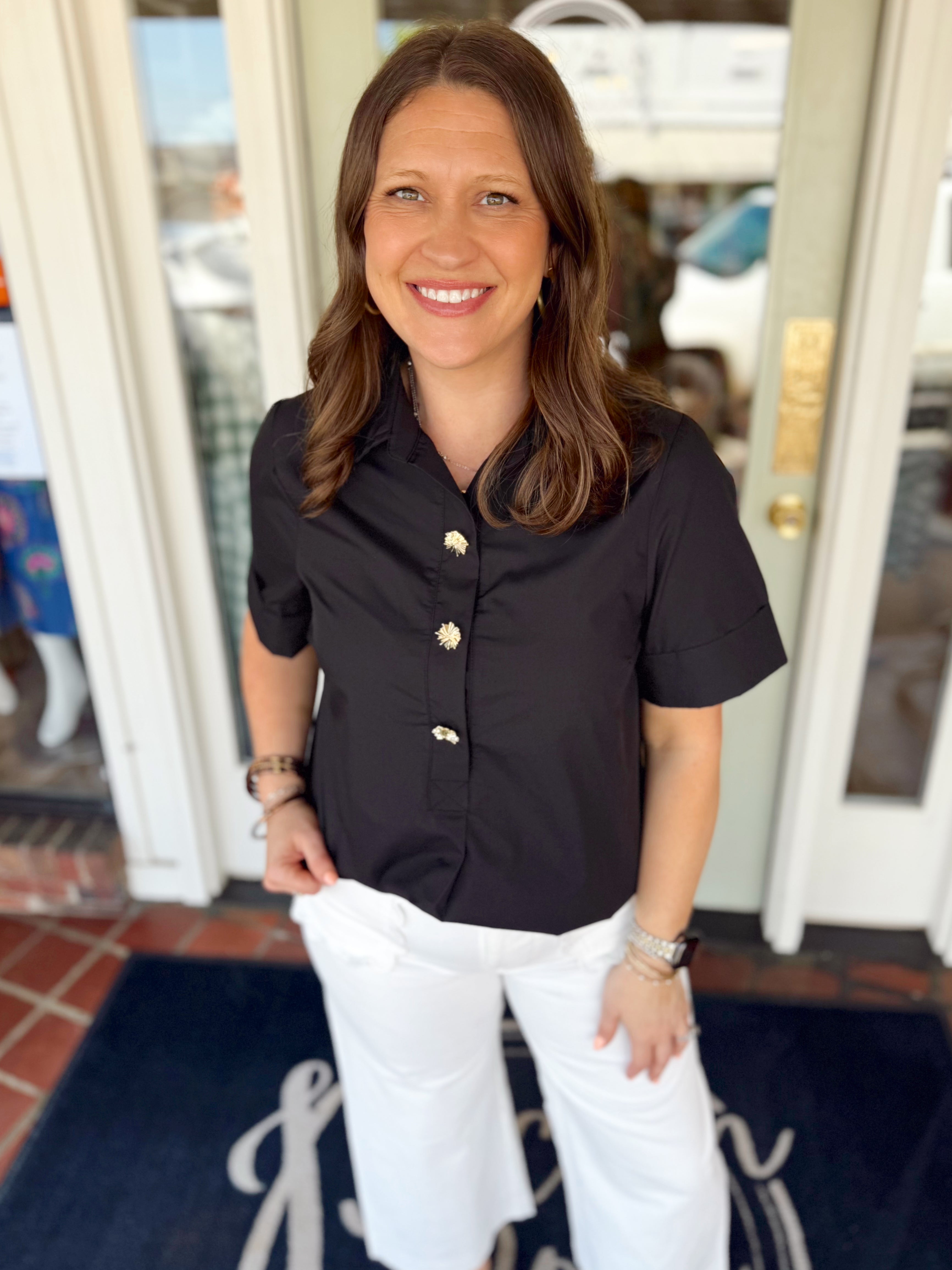 Solid black top with gold buttons on the front 