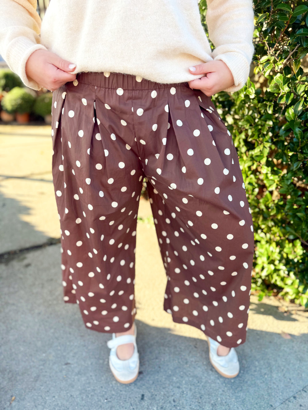  These chocolate brown pants feature an allover cream polka dot print with a relaxed wide-leg silhouette and cropped length. 