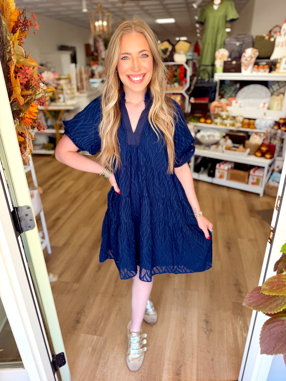  This navy mini dress features a subtle textured pattern throughout with a relaxed tiered silhouette that gives it plenty of movement. 