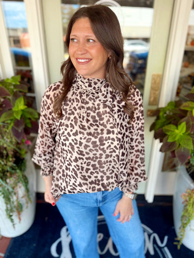  This animal print top features a chic high neckline with a ribbon tie detail for an elevated finishing touch. 