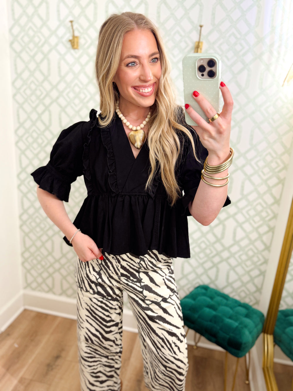  This blouse features a flattering V-neckline framed with delicate ruffle trim, puff sleeves and a gathered peplum hem. 