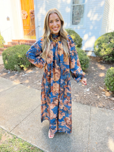 This maxi dress features a rich blue base with warm rust and brown florals.