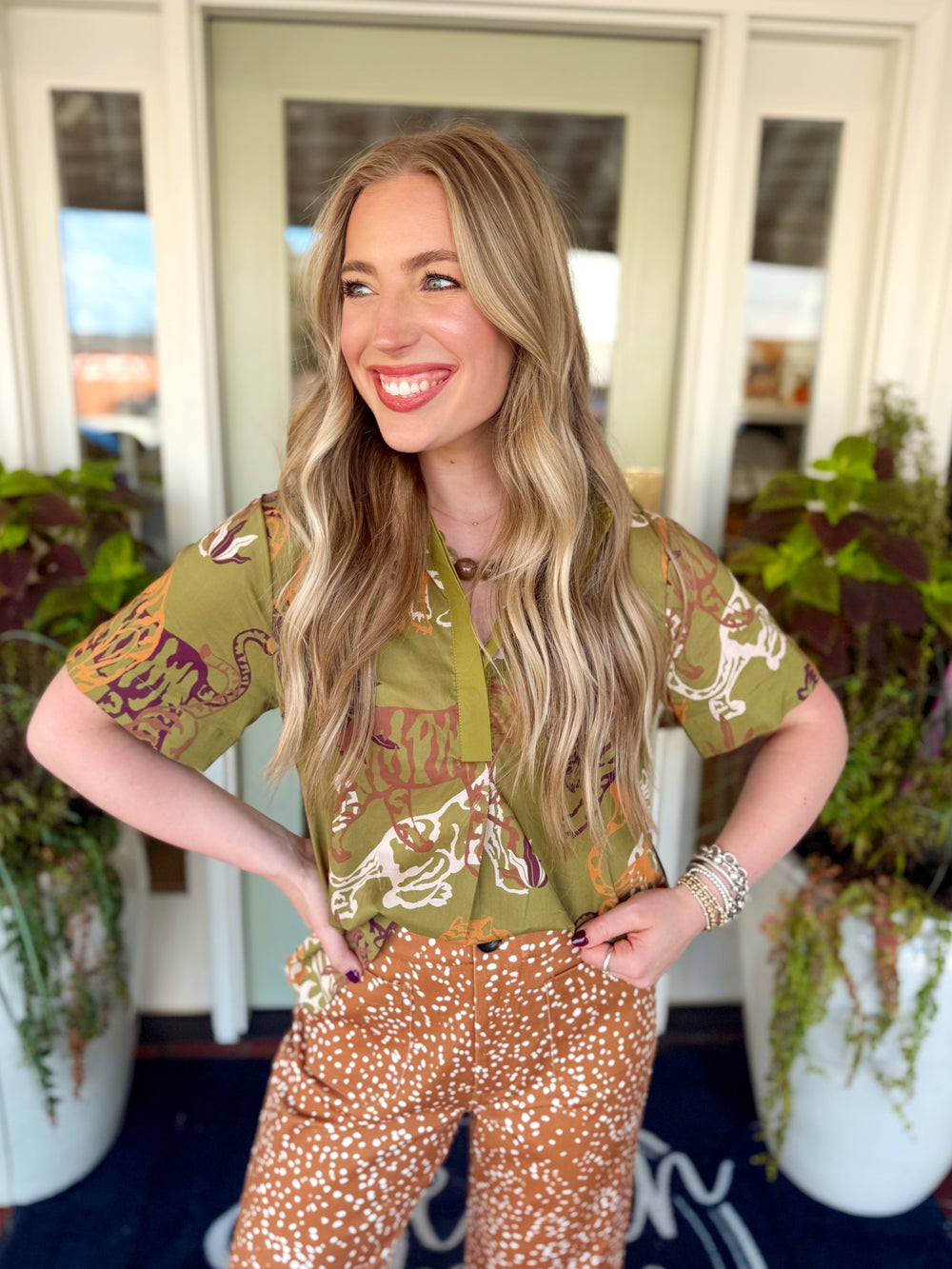 This tiger print top features a classic shirt collar, short sleeves, and a partial button front for a polished yet relaxed look. 