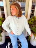 This mint and cream striped knit features thin, classic stripes with a button-up front.