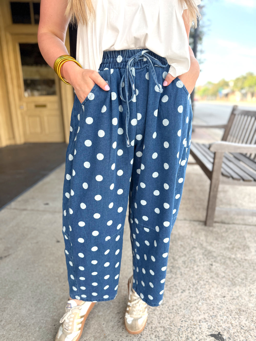 Loose blue pants with a white polka dot pattern and a matching drawstring waist.