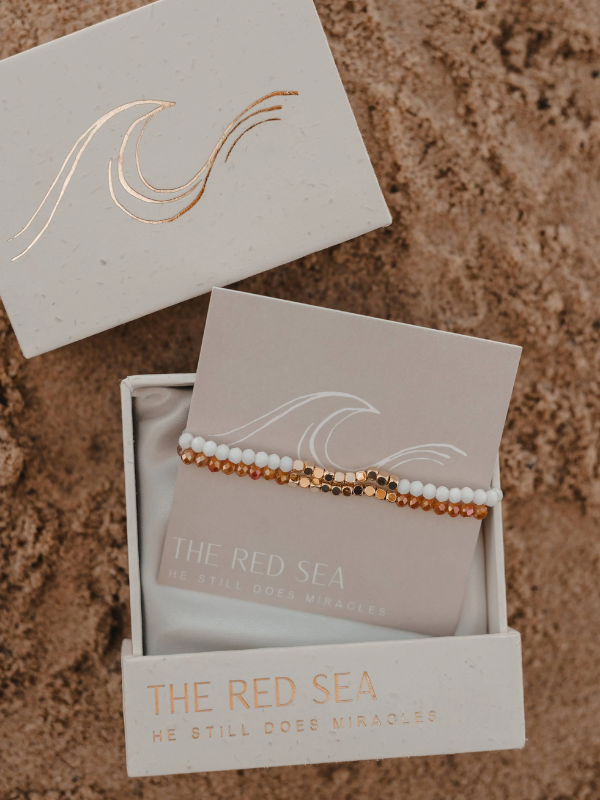 Bracelet set in a 'The Red Sea' box on a sandy background