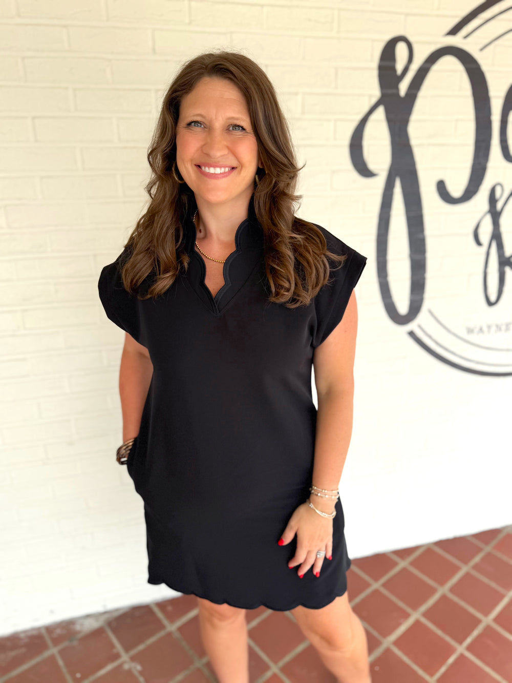 Black short-sleeve dress with a scalloped hem