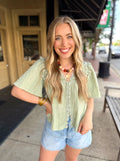 Light sage green short-sleeve blouse with lace trim.