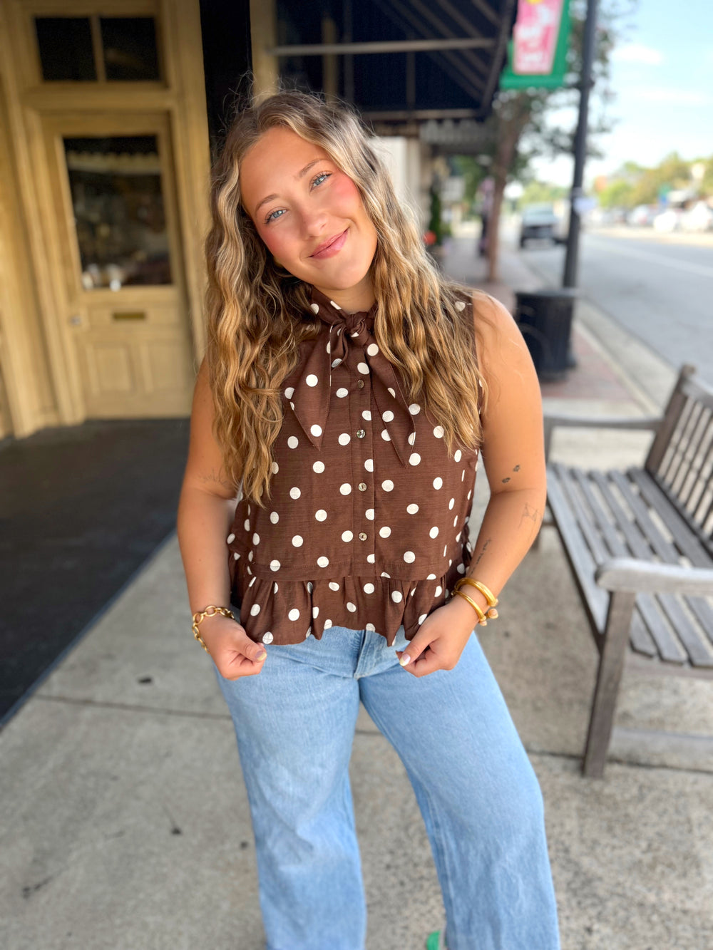 A brown sleeveless top with white polka dots.
