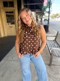 A brown sleeveless top with white polka dots.