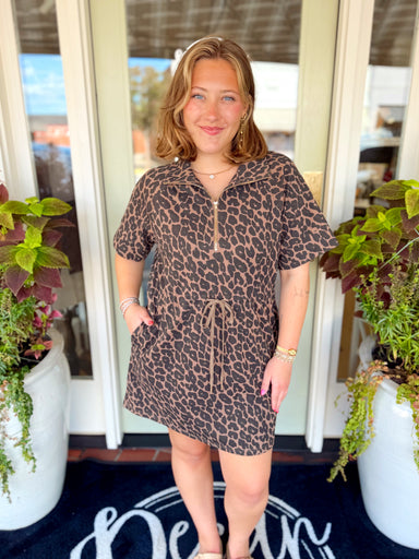 A leopard print dress with a zip-front neckline with a structured collar, short sleeves and an adjustable drawstring waist.