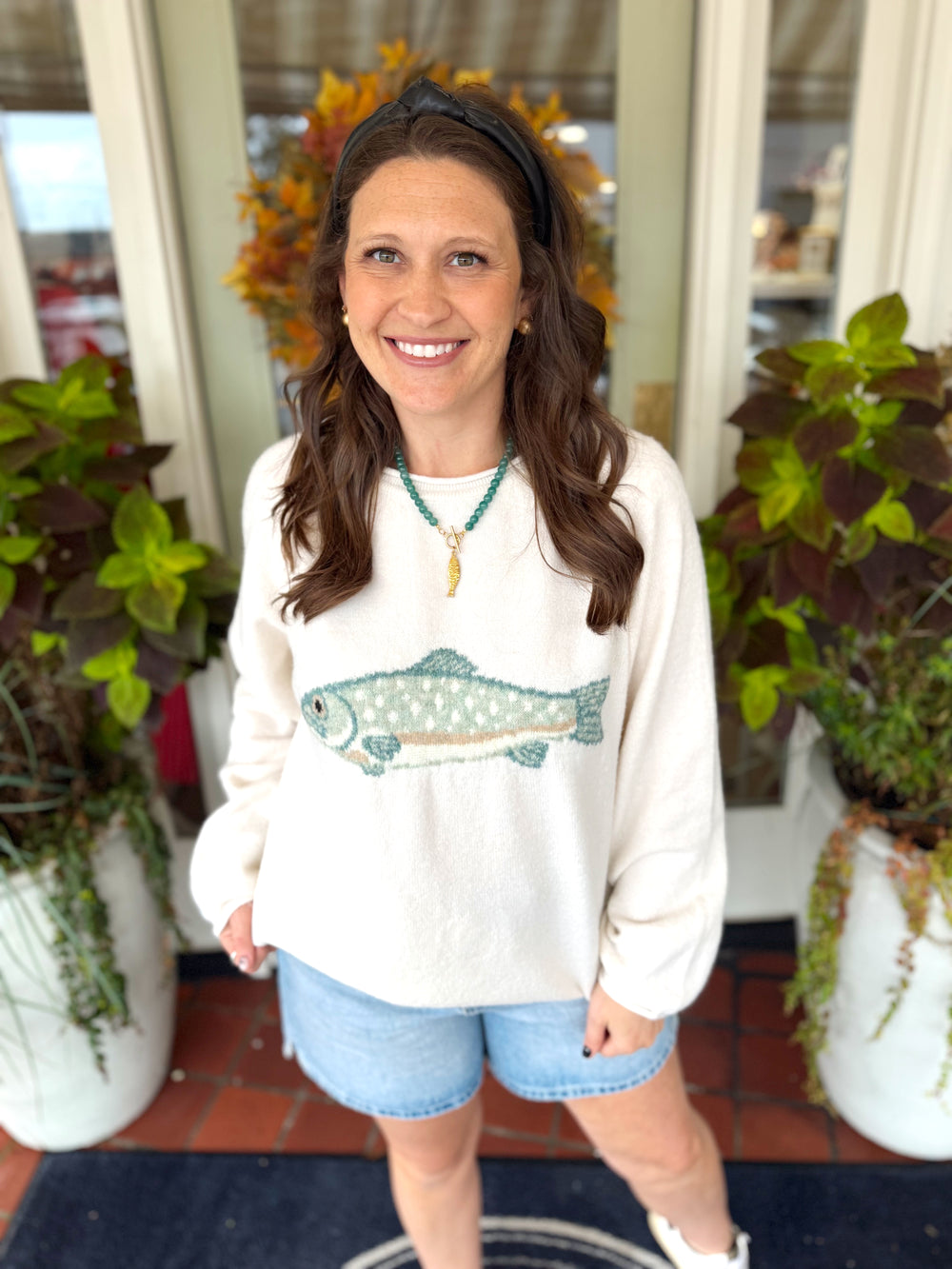 Cream sweater with teal and brown trout on the front middle 