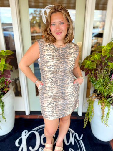 This tiger print mini dress features a relaxed shift silhouette with structured cap sleeves and side pockets