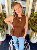 This rich chocolate brown sleeveless top features a soft suede-inspired finish with a fitted bodice that flows into a feminine peplum hem.