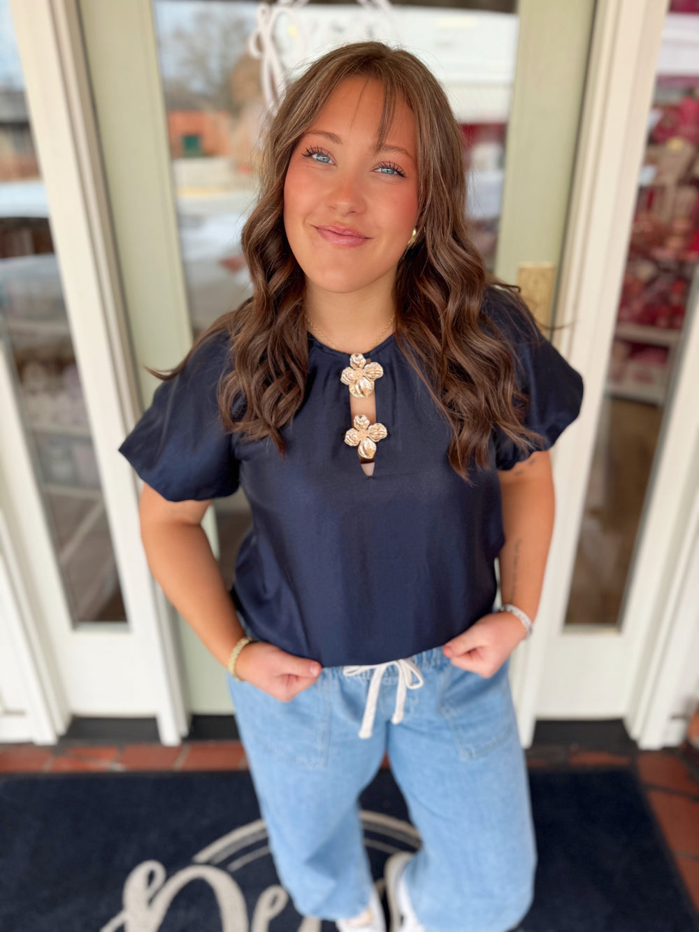 Navy bubble hem sleeve top with decorative gold flowers