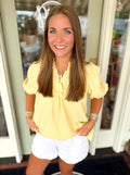 A yellow ruffle detail top with subtle puff sleeve top 