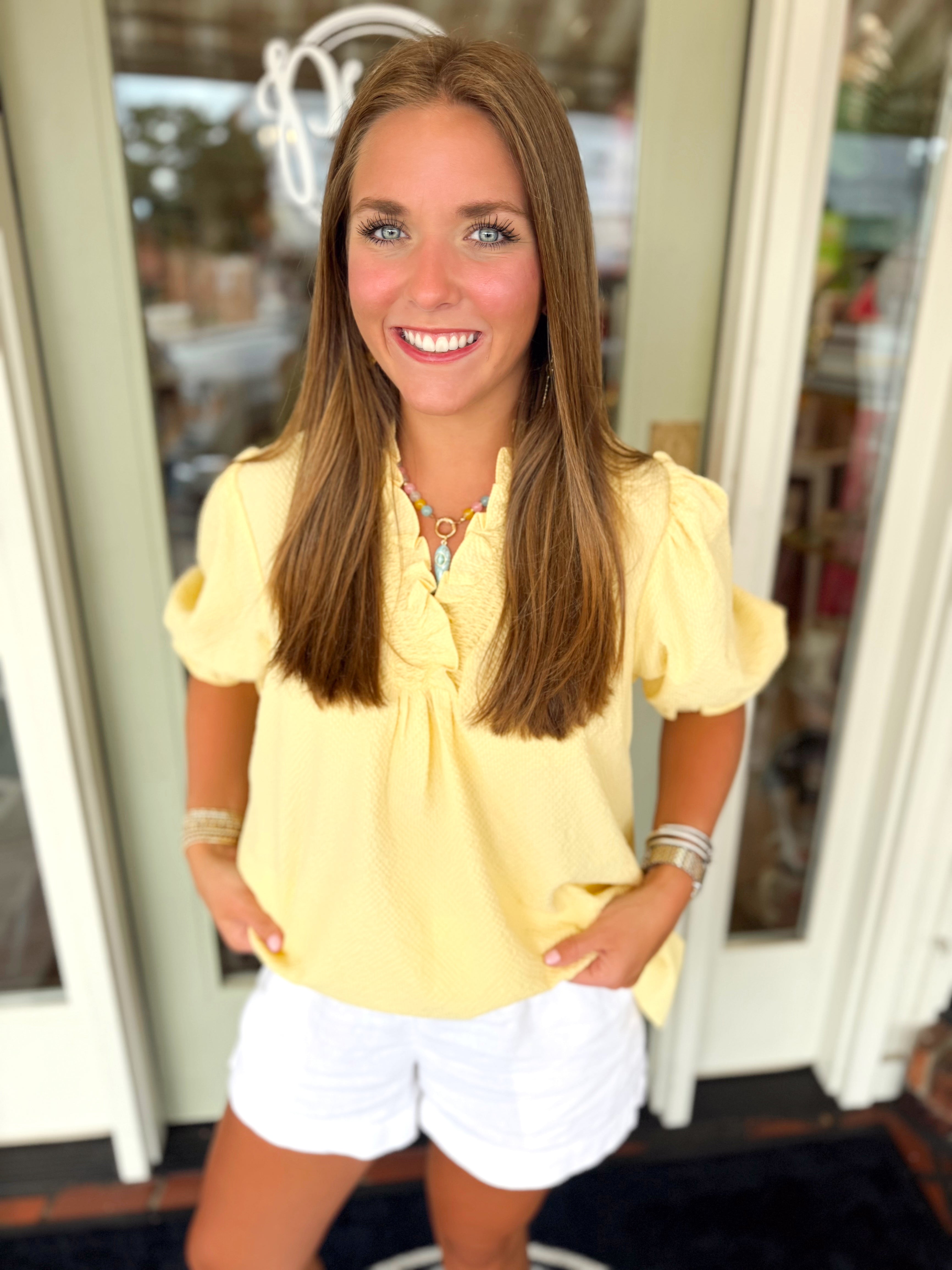 A yellow ruffle detail top with subtle puff sleeve top 