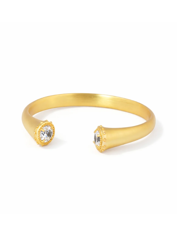 A gold open cuff bracelet with two bezel-set clear gemstones, photographed on a clean white background.