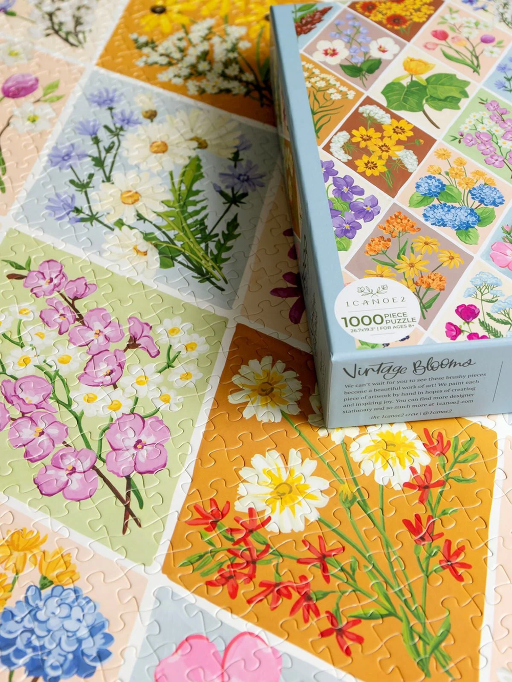 Vintage Blooms 1000-piece puzzle by 1canoe2 featuring colorful hand-painted floral designs in a patchwork pattern, shown assembled and in box.