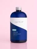 A bottle of capri BLUE Volcano fragranced hand wash, featuring a deep blue translucent bottle, a white and blue label, and a silver cap, set against a solid pink background.
