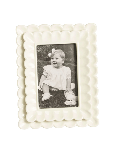 White decorative photo frame with a black and white photo of a child inside