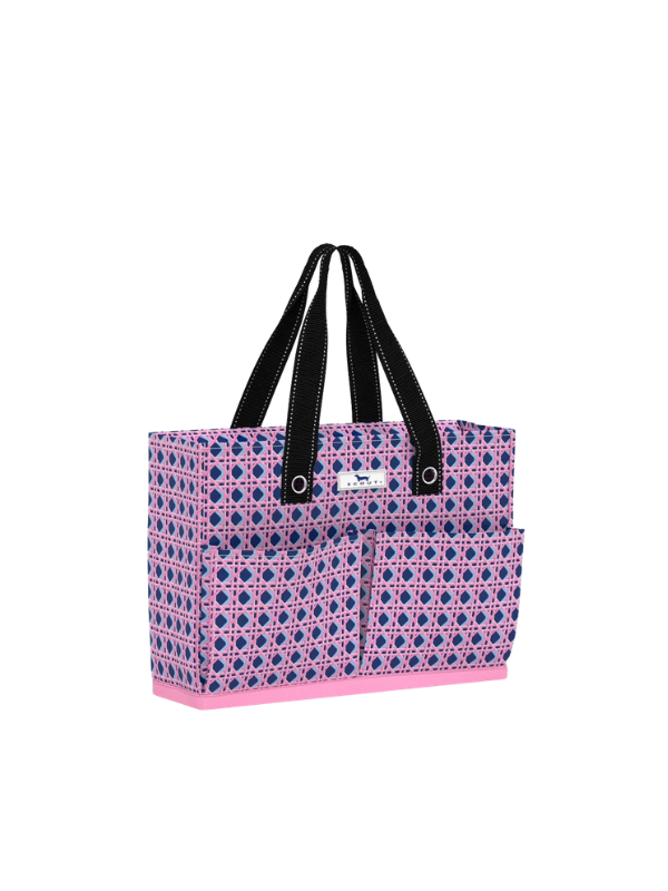 A tote bag with a pink and navy blue geometric pattern, black shoulder straps, and a pink base
