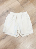 These stone khaki performance shorts feature a comfortable elastic waistband and a built-in liner for added coverage and support.
