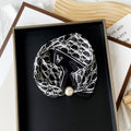 Black and white patterned scarf with a pearl center clasp 