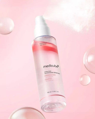 Medicube skincare serum bottle on a pink background with bubbles