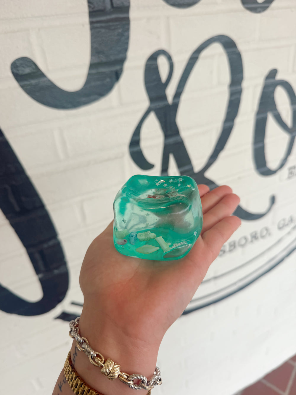 Clear sea life squishy toy filled with glitter and miniature ocean creatures inside for sensory play and stress relief.