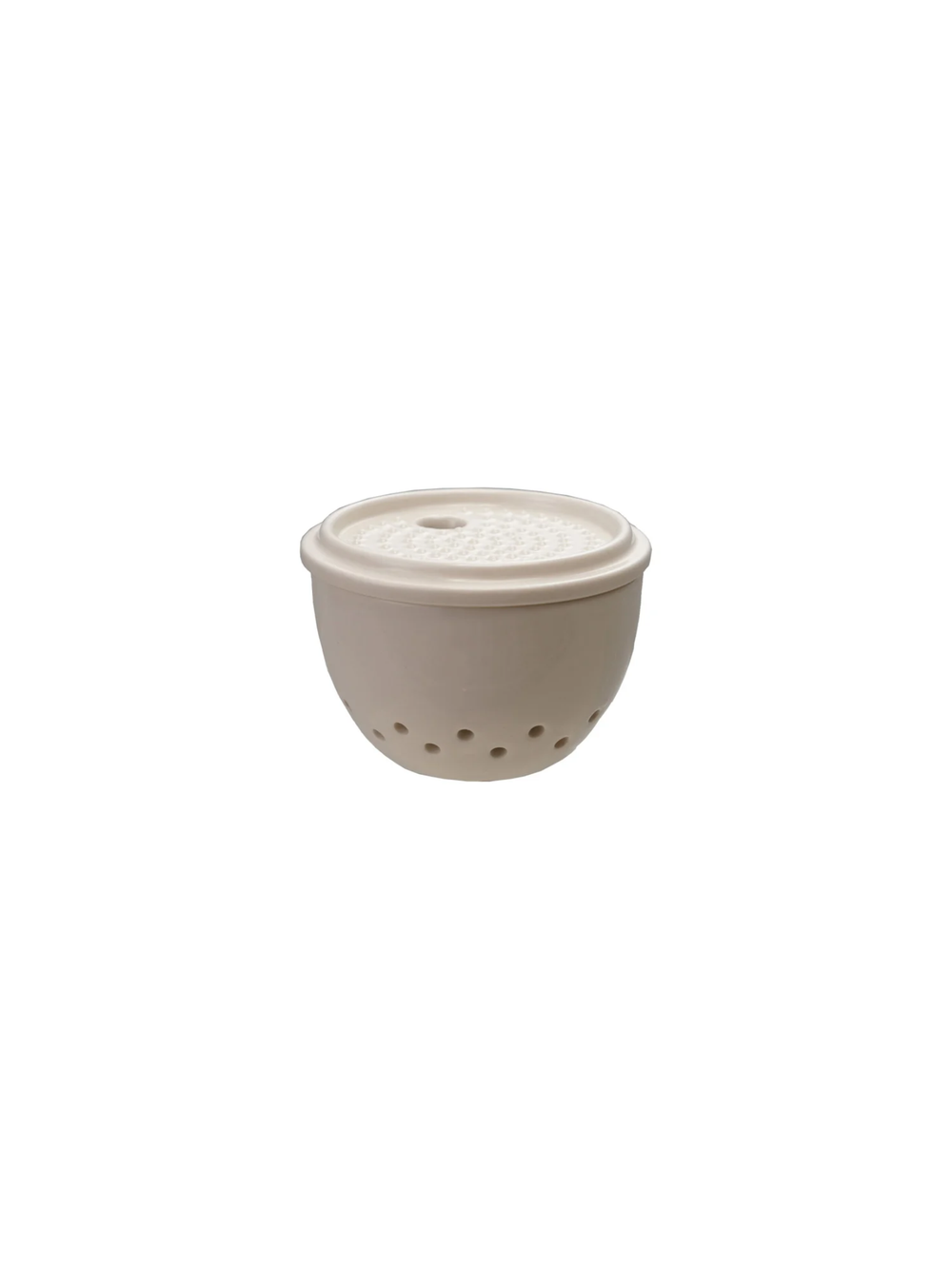 Ceramic garlic and ginger keeper with built-in grater lid and ventilated storage base, displayed with fresh garlic bulbs and ginger root.