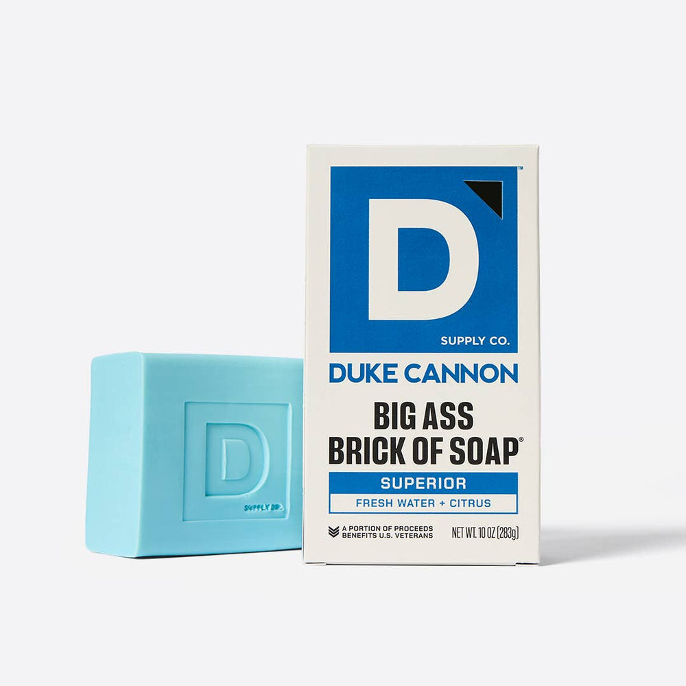 Blue bar of soap next to its packaging on a white background